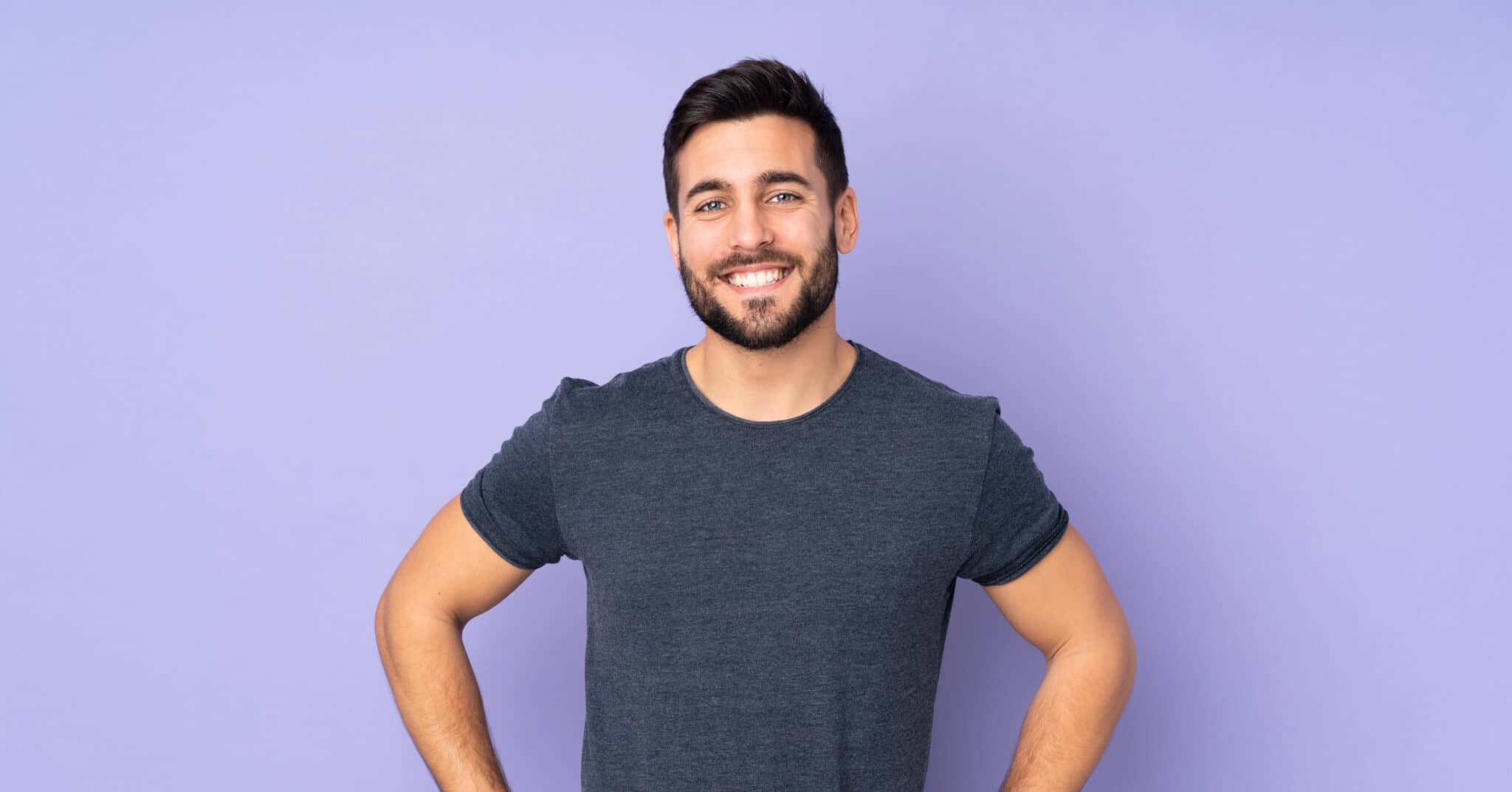 caucasian handsome man posing with arms at hip and smiling