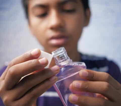 teenage boy hold a mouthwash liquid container