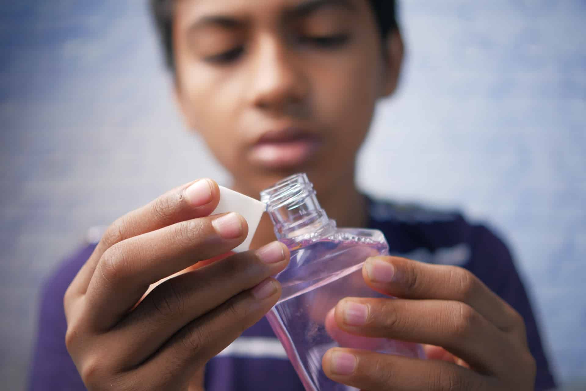 teenage boy hold a mouthwash liquid container