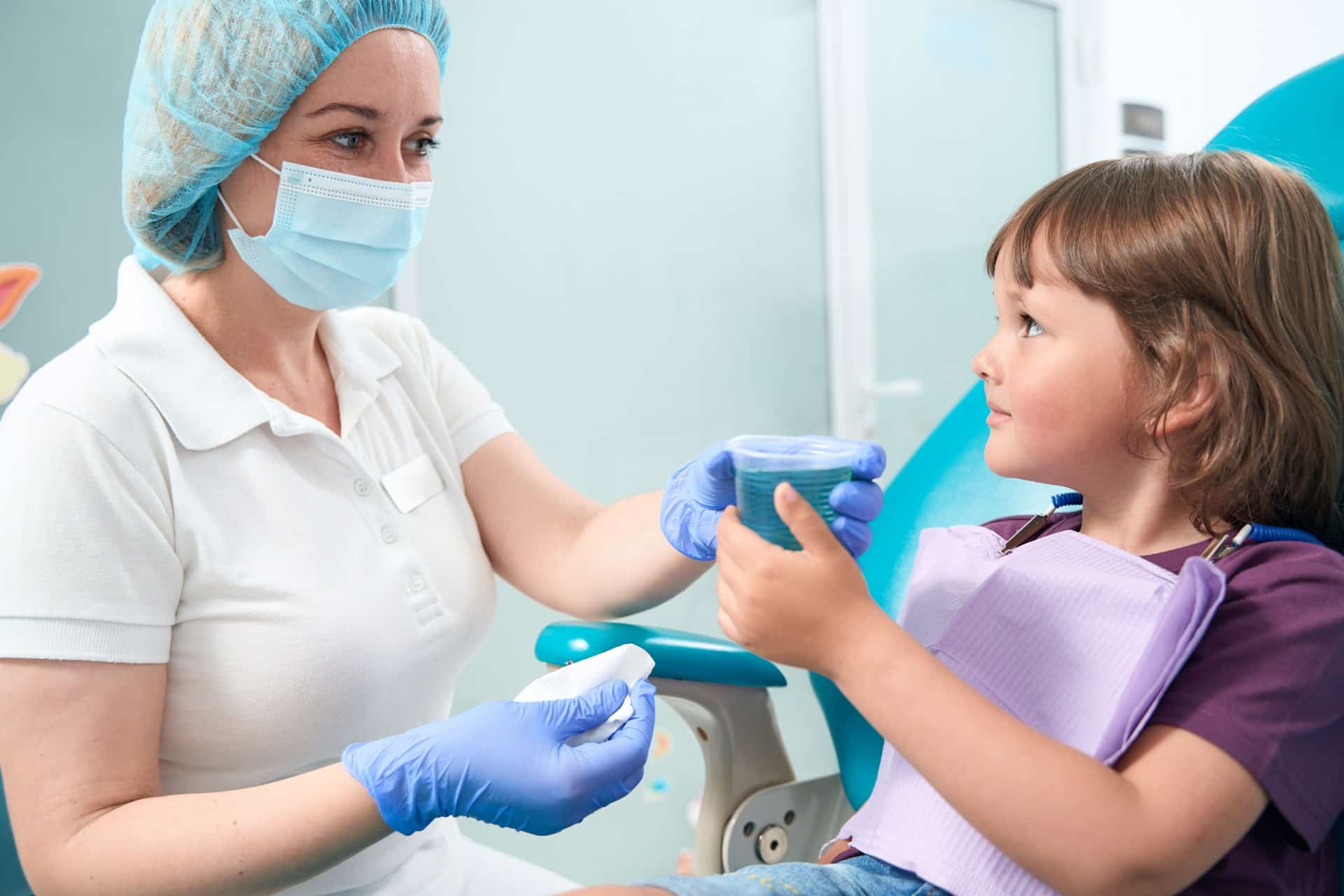 young female patient using mouthrinse after procedure