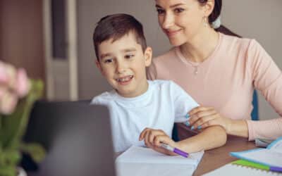 teen cute boy with braces learning homework at laptop computer and mom helping.